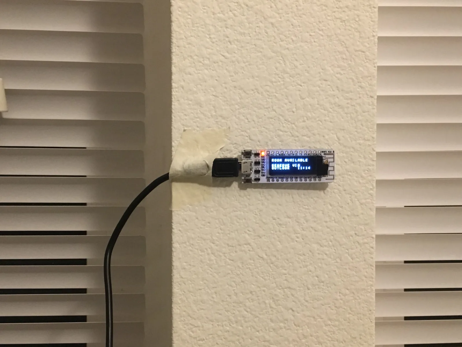 Wall mounted ESP8266 display showing the meeting room as available