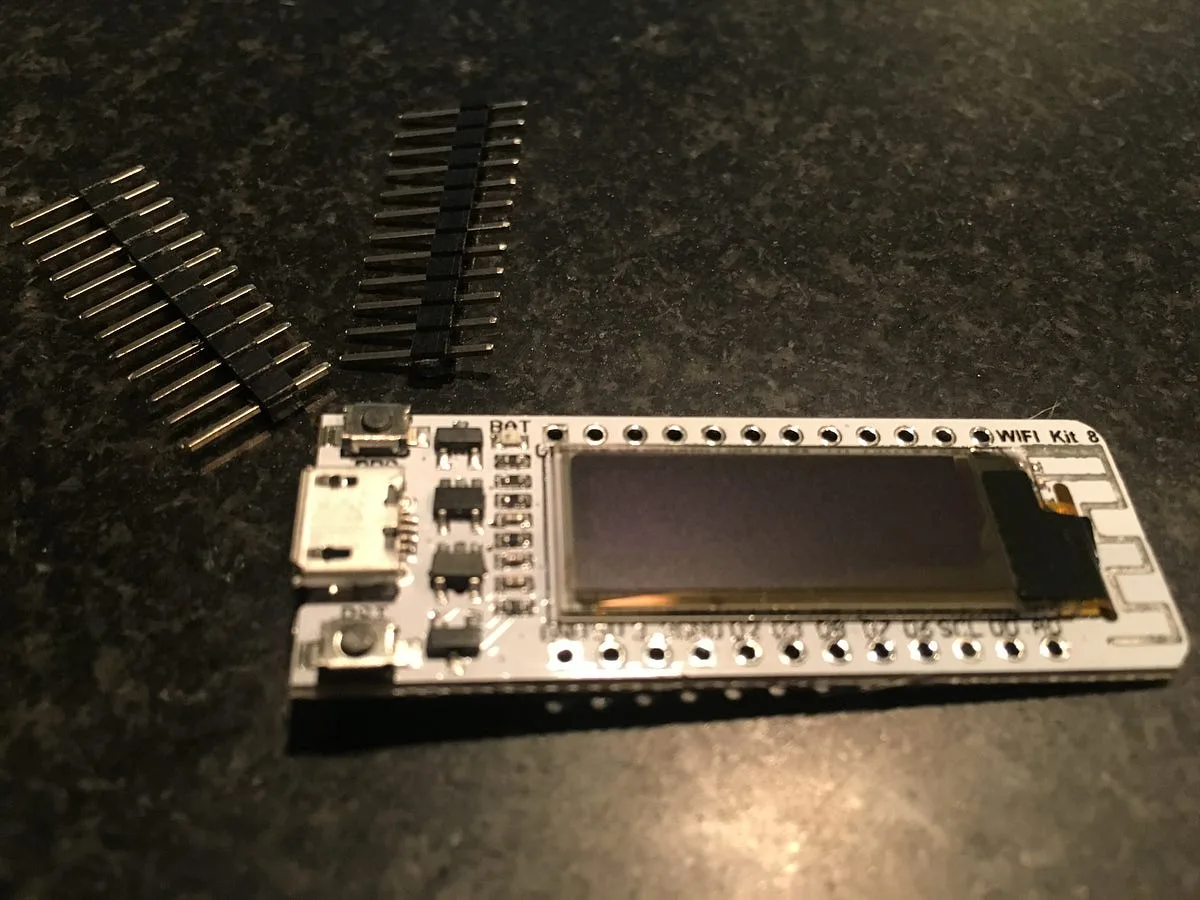 ESP8266 WiFi Kit 8 board with an onboard OLED screen and loose header pins
