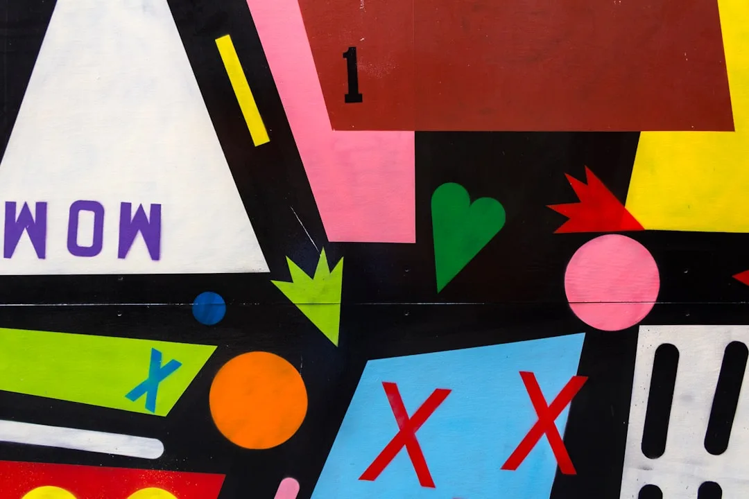Colourful abstract mural of geometric shapes, arrows and letters