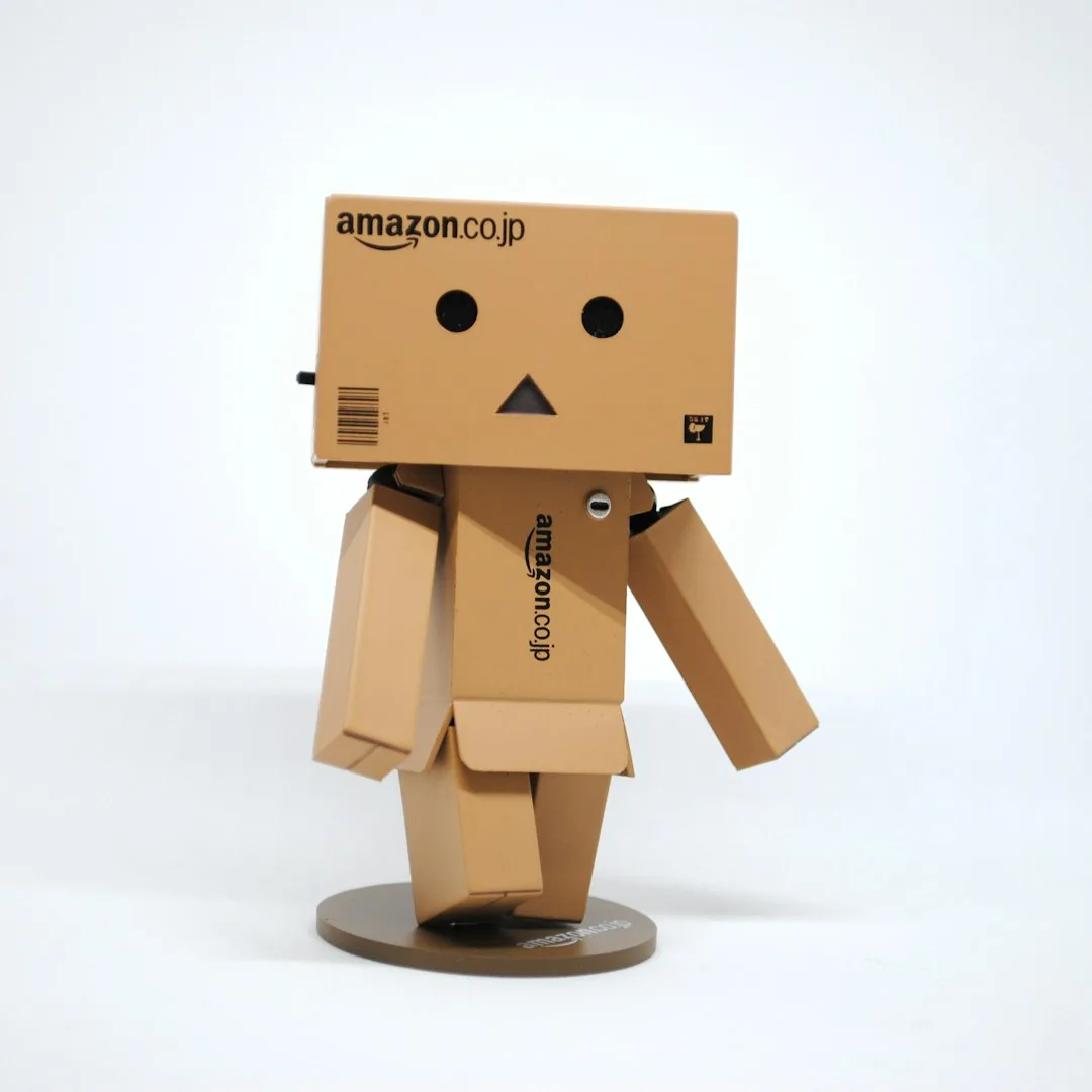 Small figure made from an Amazon delivery box on a white background