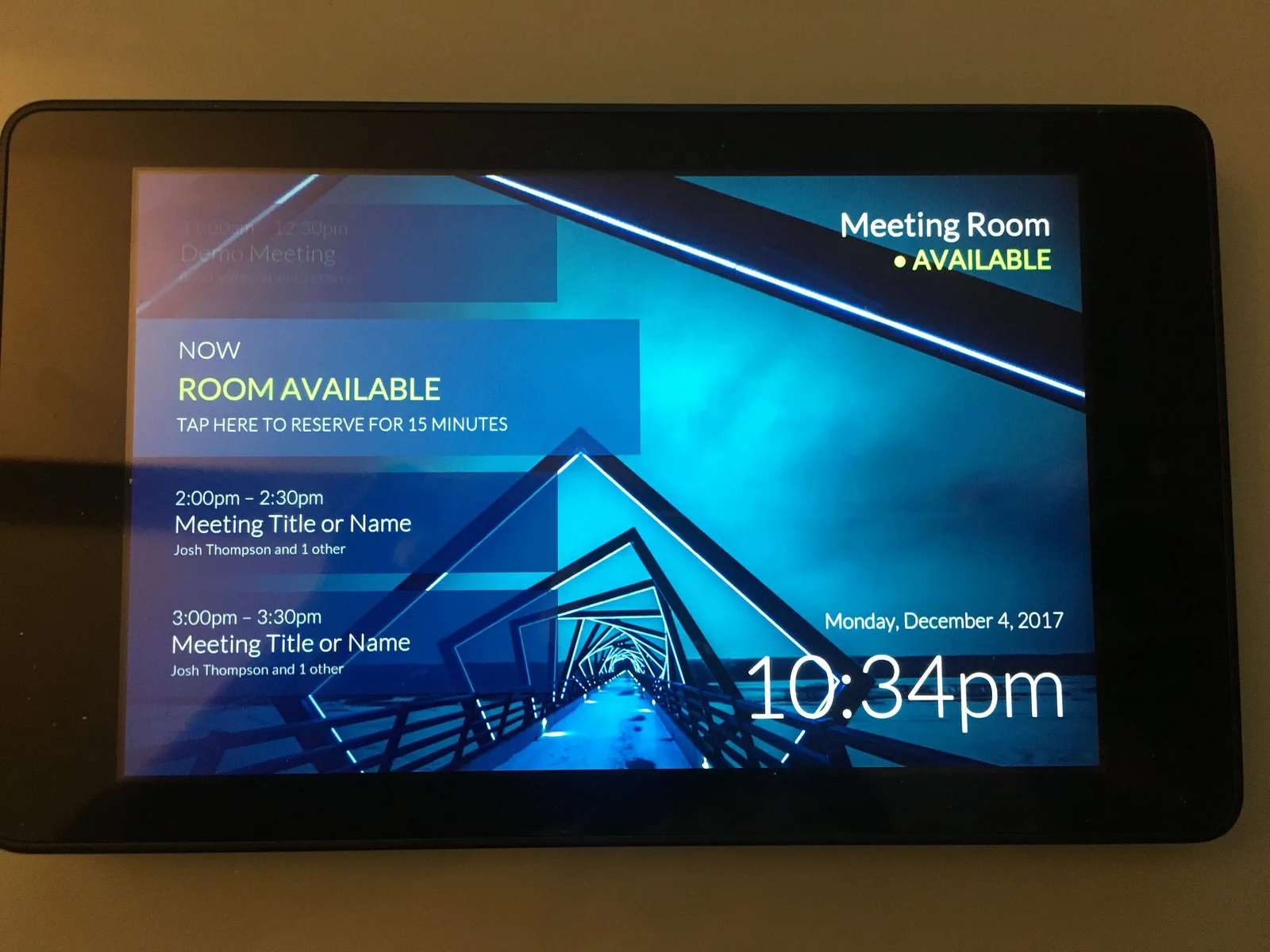 Fire tablet on a desk showing the meeting room display with the room available