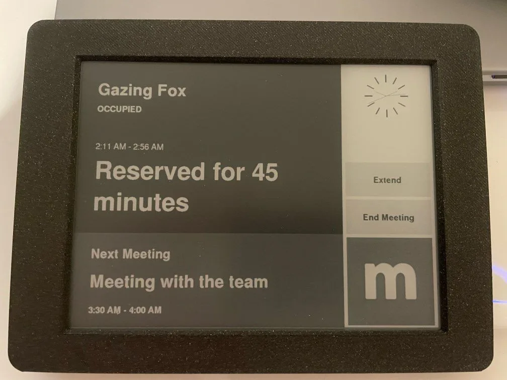 E-ink meeting room display showing the room occupied and reserved for 45 minutes with Extend and End Meeting buttons