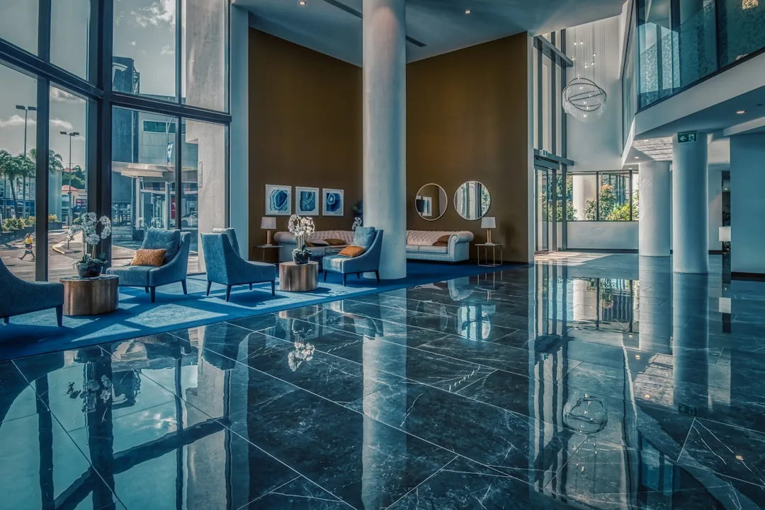 Bright office lobby with blue armchairs and a polished marble floor