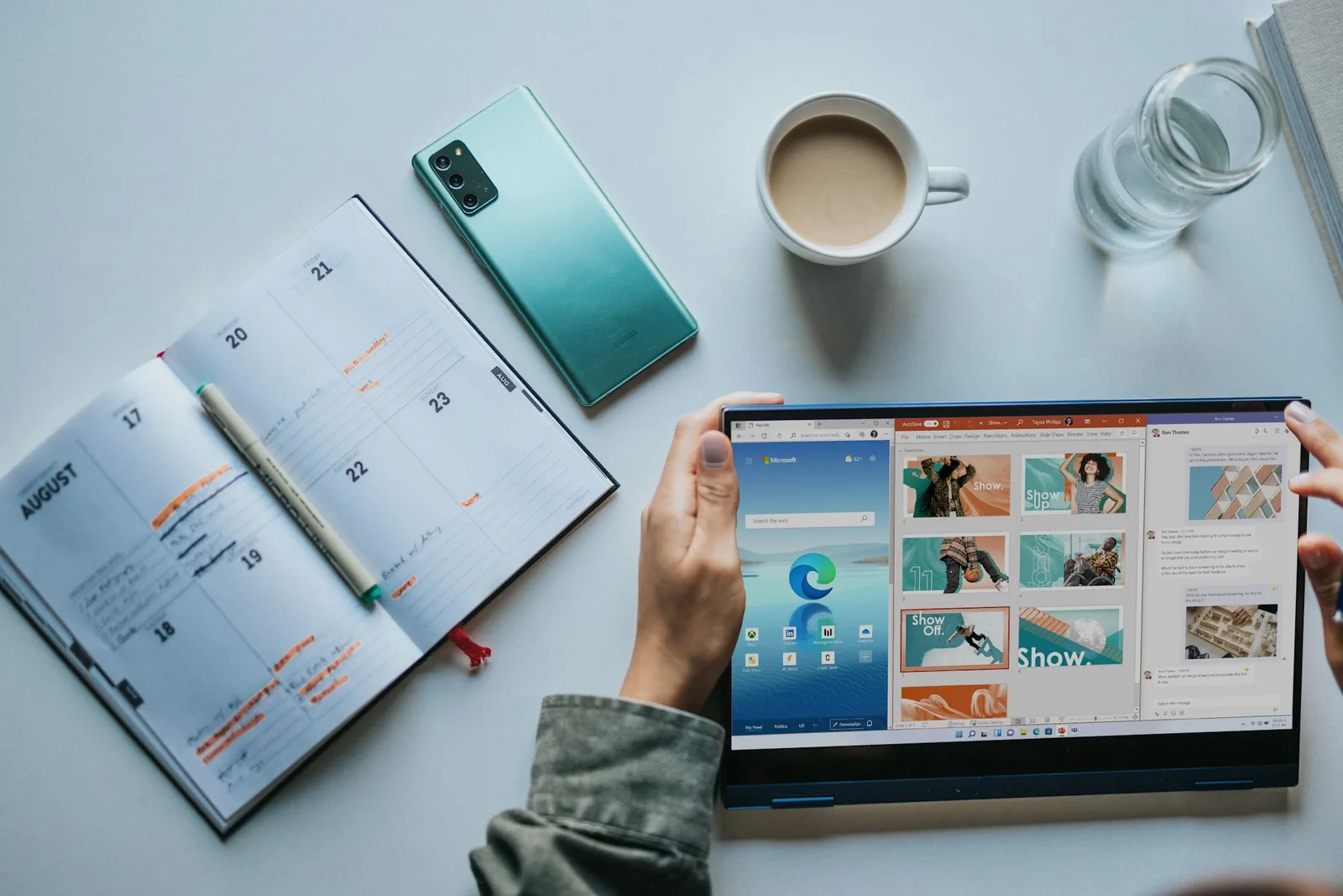 Flat lay of a paper planner, phone, coffee and a tablet showing a web browser