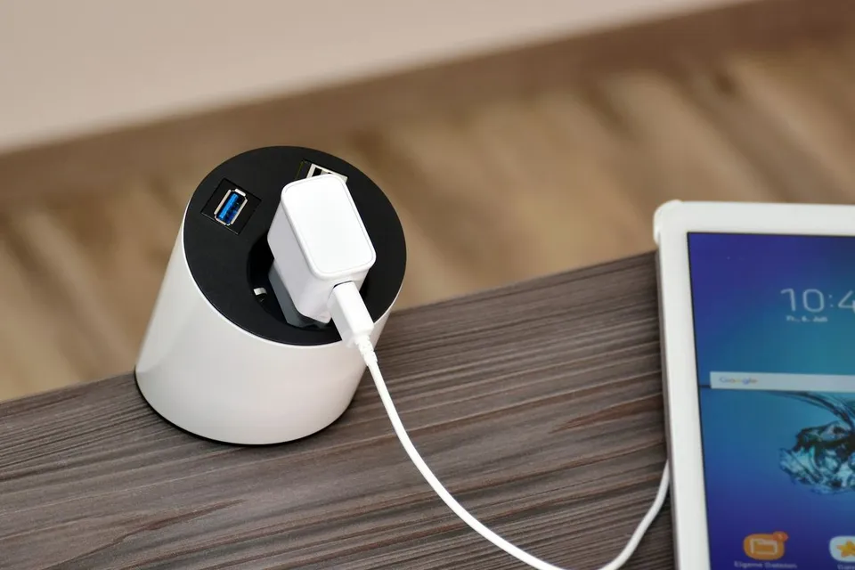 an electronic device plugged into a charger on a table